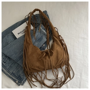 Détail d'un sac hobo en daim marron avec de longues franges de style bohème