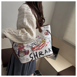 Detail showing cartoon bear graffiti tote bag with brown leather straps and large capacity
