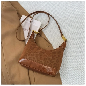 Detail of leopard print shoulder bag with brown leather base and gold hardware