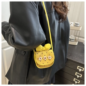 Détail du mini sac bandoulière jaune en cuir à pois avec fleurs 3D et nœud élégant