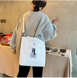 Detail of white canvas tote bag with adjustable shoulder strap and illustration