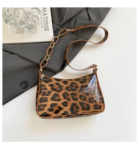 Detailed close-up of glossy leopard print faux leather bag with chain shoulder strap