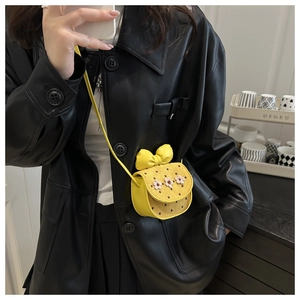 Détail du mini sac bandoulière jaune avec fleurs 3D et rabat à motif de pois élégants