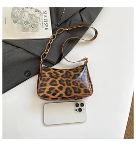 Detailed comparison of leopard print shoulder bag size next to a white smartphone