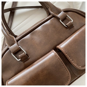 Detailed macro view of vintage brown faux leather texture and silver buckle stitching