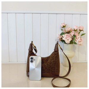 Detailed close-up of leopard print hobo bag with phone for size reference