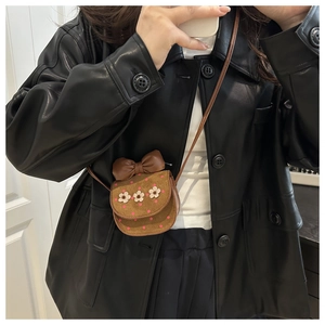 Détail du mini sac bandoulière marron avec fleurs et nœud en vue selfie miroir