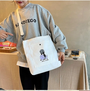 Detail of white canvas crossbody bag with purple anime illustration and wide strap