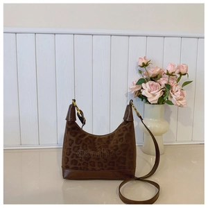 Detail view of brown leopard print hobo bag with sleek leather trim and gold hardware