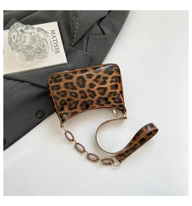 Macro view of leopard print baguette bag featuring glossy finish and elegant chain strap