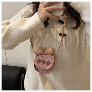 Détail du sac bandoulière rose à pois avec fleurs 3D et grand nœud décoratif