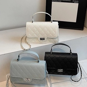 Quilted crossbody bags in white, black and blue colors with chain straps on display