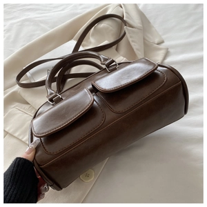 Detailed view of deep brown vintage Boston bag showing dual front flap pockets and stitching