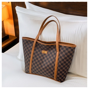 Detail of the high-capacity tote bag featuring a brown checkered pattern and metal logo tag