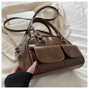 Close-up of vintage brown PU leather bag with double front pockets and silver hardware