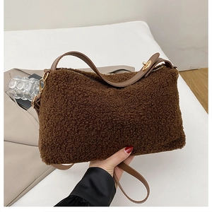 Nahaufnahme der braunen Teddy-Plüschtasche mit Lederriemen und goldenem Metallschloss