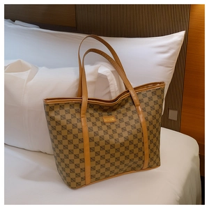 Detail of checkered tote bag with golden logo plate on a cozy bedroom background