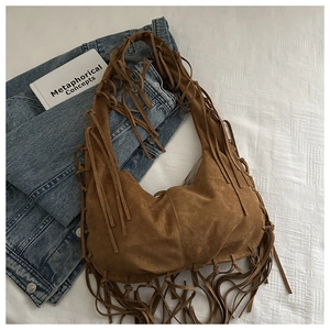 Détail du sac hobo en daim marron avec de longues franges et un style rétro bohème chic