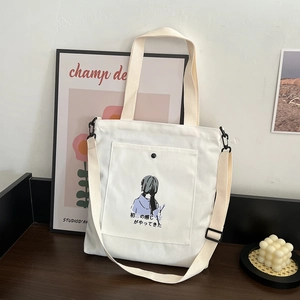 White canvas tote bag with artistic girl illustration and adjustable crossbody strap