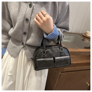 Detail of grey vintage Boston bag with dual flap pockets and soft leather texture