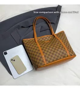 Brown monogram tote bag size comparison with smartphone and iPad on gray fabric