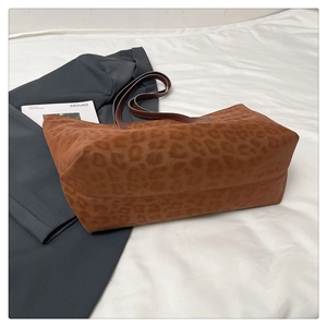 Close-up of leopard print tote bag texture and soft suede material on white fabric