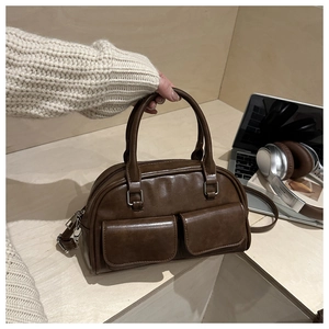 Detail of vintage brown Boston bag featuring dual front flap pockets and silver hardware