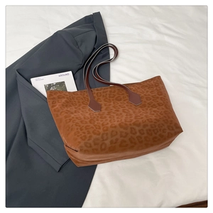Detail of soft leopard print tote bag with premium leather handles and large capacity