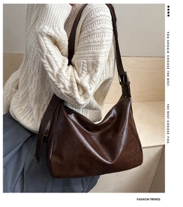 Détail du sac cabas en cuir marron foncé avec boucle argentée porté par un mannequin