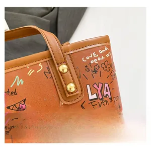 Gros plan du sac cabas en cuir marron avec imprimés graffiti colorés et rivets dorés