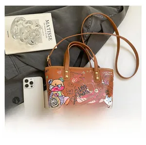 Sac fourre-tout en cuir marron avec graffiti colorés et détails de clous dorés fins