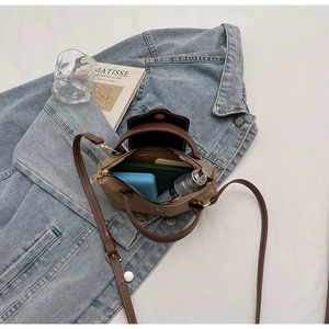 Top view of open brown leather bag showing interior storage space with essentials