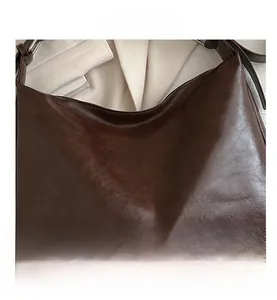 Vue détaillée du sac hobo marron foncé avec texture en cuir brillant au style vintage