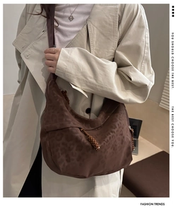 Detail of leopard print half-moon crossbody bag with woven drawstring and textured finish