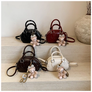 Détail de sacs bowling en cuir gaufré élégants avec breloques de personnages en peluche