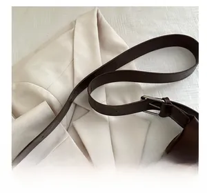 Détail de la bandoulière en cuir marron foncé du cabas avec boucle en métal argenté