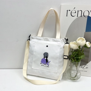Detail of white canvas tote bag with girl illustration and adjustable buckle strap