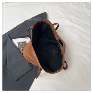 Top view of brown leather tote bag with large capacity, interior lining, and zipper detail