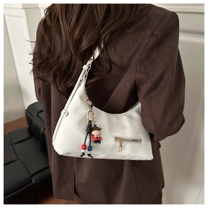 Detailed view of white Hobo shoulder bag with cute doll charm on a brown blazer outfit