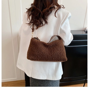 Dettaglio borsa Boston marrone in peluche con tracolla in pelle e fibbia dorata