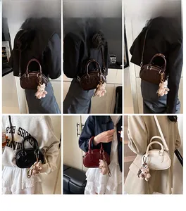Mini sacs Boston en quatre couleurs avec motifs embossés et breloques peluche sur modèle