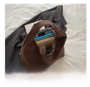 Spacious interior of brown suede tote bag holding a tablet and notebooks