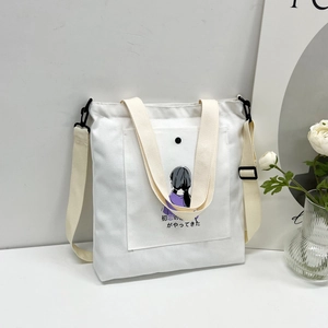 Detail of white canvas tote bag with anime illustration and adjustable black strap