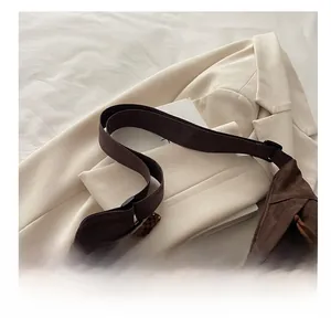 Macro shot of dark brown crossbody bag with leopard print texture on a beige suit