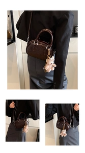 Détail du sac bowling marron brillant avec relief et porte-clés en peluche rose