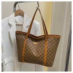 Detail of a brown tote bag with geometric logo print and golden label on white suit