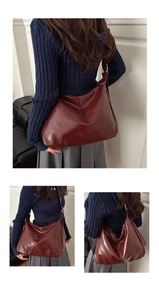 Détail du sac hobo en cuir brillant bordeaux avec bandoulière réglable et grande capacité