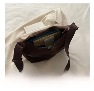 Top view of large dark brown tote bag interior showing spacious storage for books and tech