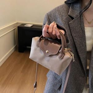 Contrast mini nylon handbag with leather flap and crossbody strap shown with blazer