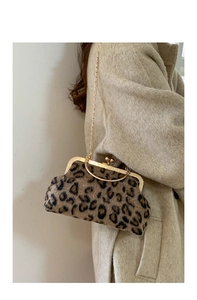 Close-up of leopard print plush shell bag with gold chain strap on a beige coat